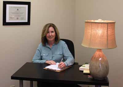 Kathy at desk with lamp on